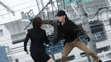 a man in a black hat is fighting another man in a black suit
