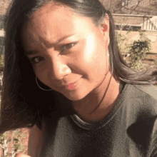 a woman wearing hoop earrings looks at the camera