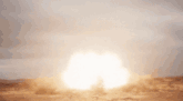 a large explosion in the middle of a desert with smoke coming out of it
