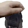 a pixelated image of a person 's hand holding a black object .