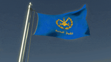 a blue flag with a gold anchor on it is flying in the wind