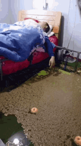 a person laying on a bed with a blue comforter