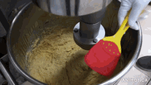 a person is using a yellow spatula in a mixing bowl that says made in animotica