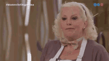 a woman applauds in front of a screen that says #masterchefargentina