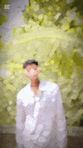 a blurry picture of a man in a white shirt with the letter x on the bottom right