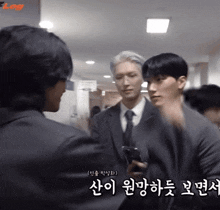 a man in a suit and tie is talking to another man in a suit