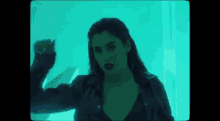 a woman is standing in front of a blue wall in a room .