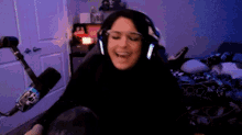 a woman wearing headphones and a microphone is sitting in front of a microphone in a room .