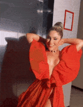a woman in a red dress is standing in front of a sign that says ' elevator ' on it