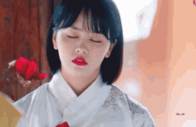a close up of a woman with her eyes closed in front of a flower