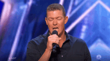 a man singing into a microphone on nbc