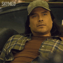a man wearing a hat and plaid shirt is saying oh shit