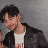 a man wearing a black leather jacket and a t-shirt that says " faithful "
