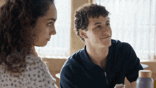 a man and a woman are sitting at a table and talking