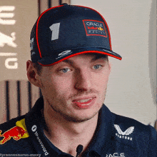 a man wearing a hat that says oracle racing is talking into a microphone