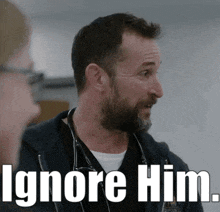 a man with a beard is wearing a stethoscope around his neck and says ignore him .