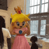 a mascot dressed as princess peach is standing in front of a window
