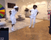 two men are dancing in a living room in front of a t mobile sign .