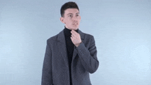 a man wearing a black and white checkered shirt is making a middle finger gesture