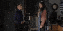 a man and a woman are standing in a room .