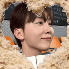a person 's face is visible through a hole in a heart shaped piece of paper