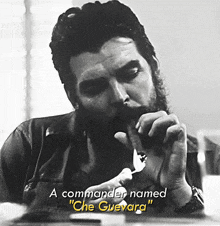 a man with a beard is smoking a cigar and the caption says " a commander named " che guevara "