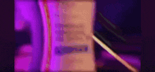 a purple light is shining on a book with a pen .