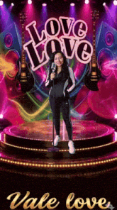 a woman singing into a microphone on a stage with the words love love vale love