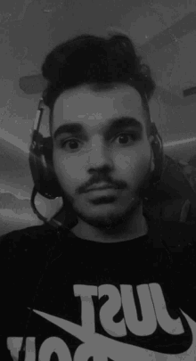 a black and white photo of a man wearing headphones and a t-shirt that says ' ncl '