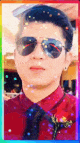 a man wearing sunglasses and a red shirt is in a rainbow frame