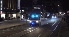 a white van is driving down a street at night