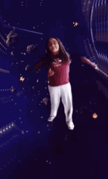 a girl wearing a shirt that says ' i love you ' on it is standing in a dark room