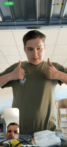 a man giving a thumbs up in front of a phone that says 12:49 on it