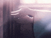 a close up of a person 's hands with a blurred background and a few letters visible