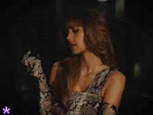 a woman wearing a snake print dress and gloves looks down