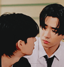 a man in a white shirt and tie looks at another man with his eyes closed