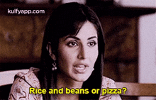 a woman is sitting at a table talking about rice and beans or pizza ?