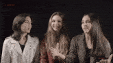 three women standing next to each other with the words " the warning " on the bottom