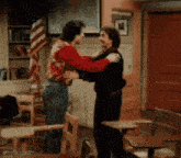 a man in a red shirt is hugging another man