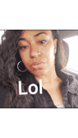 a woman sitting in a car with a lol sign on her face