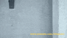 a gray wall with a youtube link on the bottom