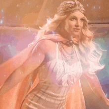 a woman in a white dress with a pink cape on her shoulders