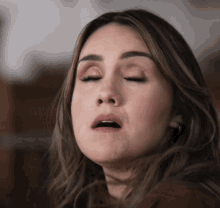 a close up of a woman making a funny face with her eyes closed
