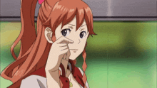 a girl with red hair and a ponytail is touching her face