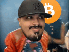 a man with a beard wearing a hat with the letter b on it .