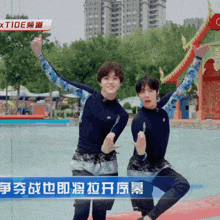two young men are standing next to each other in front of a sign that says " xtide "