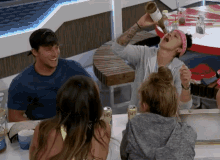a group of people are sitting around a table with a can of iced tea in front of them