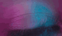 a close up of a person 's eye with a purple background