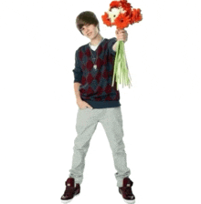a young man is holding a bouquet of flowers in his hand