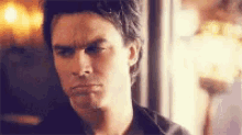 a close up of a man 's face with a slight smirk on his face .
